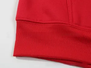 Macro detail of red hoodie ribbed cuff and precise double-needle stitching quality