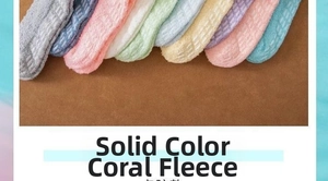 Row of colorful coral fleece socks in pastel shades on a warm brown surface