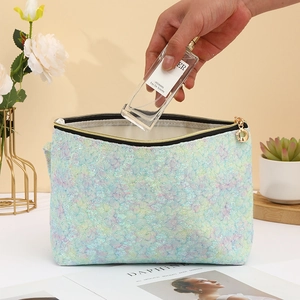 Blue iridescent scale textured cosmetic bag with gold zipper detail and wide opening