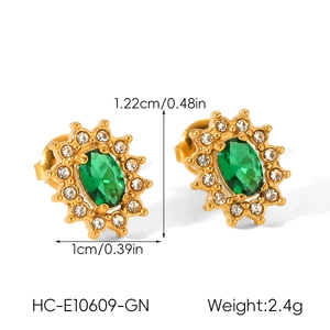 Macro view of gold vintage starburst earrings with green zircon and pavé crystals