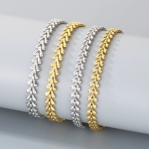 Wheat ear link chain bracelets in gold and silver finish on a display stand
