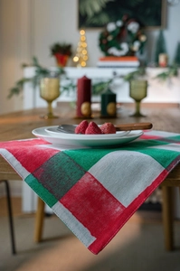 Close-up of classic red and green plaid Christmas table runner with rustic woven texture