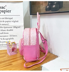 Pink sequin kids backpack with bunny ears and adjustable straps on wooden table