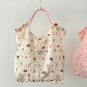 Detail of cream bubble fabric tote bag with pink handles and cartoon puppy prints