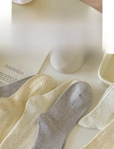 Detail of speckled cotton socks with ribbed texture in warm earth tones for winter style