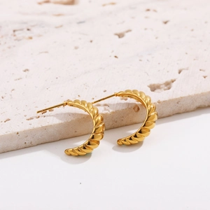 Detailed close-up of 18K gold plated hoop earrings with a textured croissant pattern
