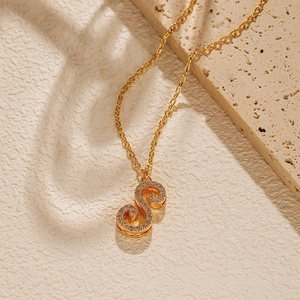 Detail of 18K gold plated S-letter pendant with sparkling zircons on a delicate chain