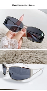 Detail of silver Y2K futuristic sunglasses with hollow geometric temple design and grey lens