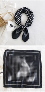 Detail of square silk scarf with white polka dots on black fabric for elegant styling