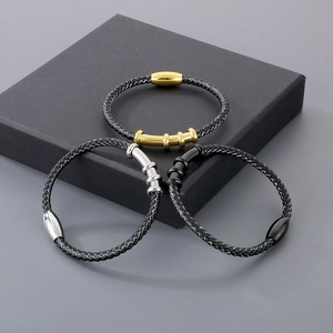 Three braided leather bracelets with gold, silver and black magnetic clasps on a gift box