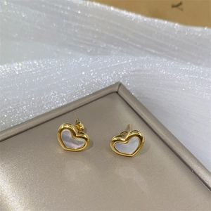 Elegant gold heart earrings with white mother of pearl inlay on champagne pedestal