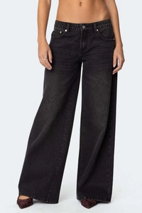 Détail du pantalon en denim noir à jambes larges montrant la texture et l'effet délavé