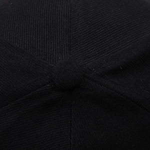 Macro shot of black baseball cap crown showing twill fabric texture and top button detail
