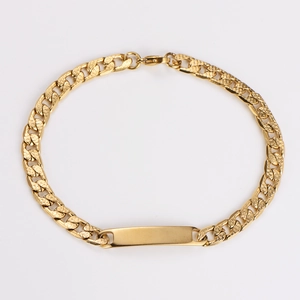 Close-up of golden hip hop curb chain bracelet with a smooth rectangular engraving plate