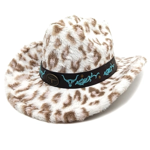Détail du chapeau de cowboy léopard avec bande en cuir brodée et badge de tête de taureau