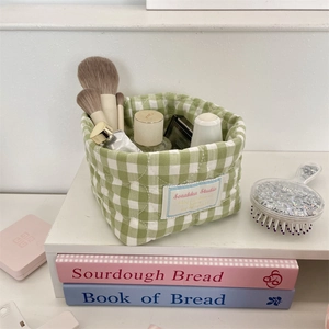 Macro detail of quilted gingham fabric organizer basket for desktop cosmetics storage