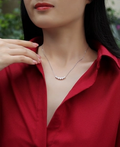 Close-up of 925 sterling silver necklace with five moissanite stones on a model