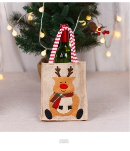 Detail of burlap Christmas gift bag with reindeer applique and festive stripe handle