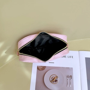 Pink heart-embroidered crossbody mini bag with open zipper showing black interior lining