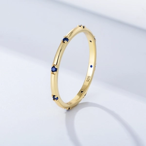 Detailed macro view of gold plated 925 silver ring band with inlaid blue zircon stones