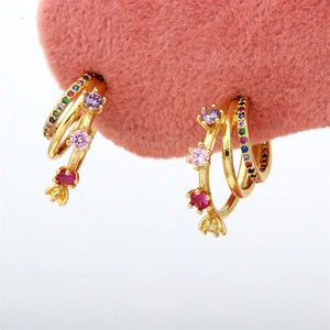 Detail of three-layer C-shape gold earrings with colorful zircon and purple gemstones