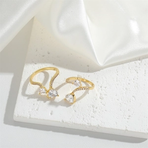 Minimalist gold adjustable open heart rings with pear-shaped cubic zirconia on silk fabric