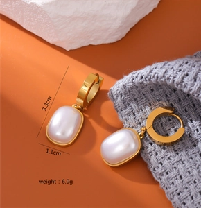 Detail view of square pearl earrings with golden titanium steel frame and 3.3cm size