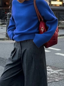 Close-up of blue knit texture on a long-sleeve crew neck sweater with ribbed cuffs