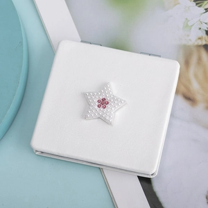 Detail of white PU leather pocket mirror featuring pearl star and pink rhinestone decor