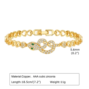Detailed view of gold snake bracelet with AAA cubic zirconia and green gem eyes