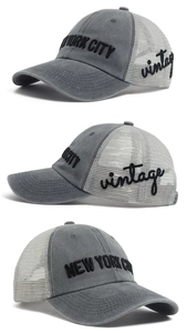 Close-up of vintage embroidery on gray and white mesh trucker cap with New York lettering