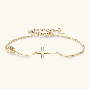 Dettaglio del bracciale in moissanite dorata con ciondolo a croce e diamante a castone