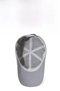 Detail of grey baseball cap showing laser-cut ventilation holes and adjustable strap