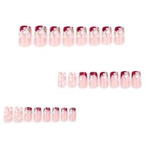 Short square press-on nails with red French tips and fresh white flower patterns
