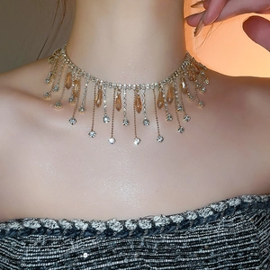 Detail of amber crystal tassel choker with white diamonds on golden metal on model