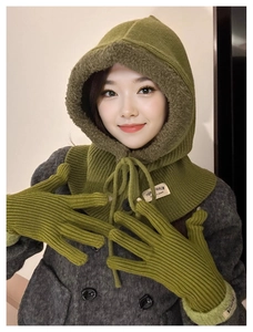 Close-up of grass green knitted balaclava hood and matching winter gloves set for women