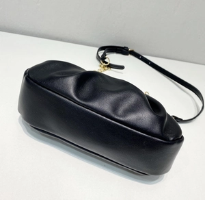 Detailed close-up of pleated black faux leather cloud bag with gold chain strap detail