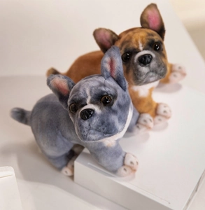 Detail of realistic French Bulldog plush toys in grey and tan with soft fur textures