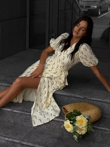 Detail of floral wrap dress with puff sleeves and yellow tulips on ivory cotton fabric