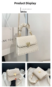Detail of white heart-shaped metal buckle on quilted PU leather crossbody handbag