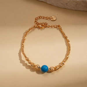 Detail of 18K gold plated beaded necklace with turquoise stone and heart pendant