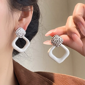 Minimalist silver geometric twisted square drop earrings with white enamel finish