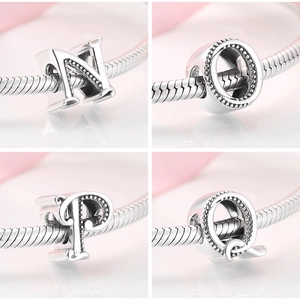Detail of silver letter charms N, O, P, Q with beaded texture on a snake chain bracelet