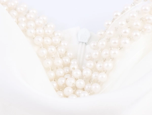 Detail of elegant white dress showing pearl beading and invisible zipper closure