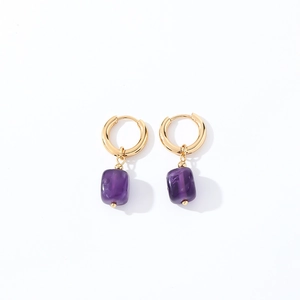 Macro shot of gold polished hoop earrings with square purple natural stone pendants
