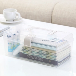 Transparent plastic storage box with handle and buckle on white desk home setting