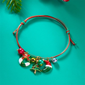 Detail of hand-woven red and green Christmas bracelet with tree and wreath charms