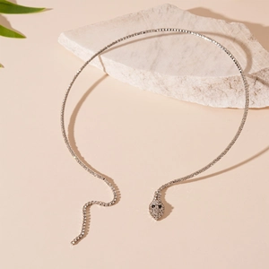 Détail du ras de cou serpent argenté avec zircons blancs sur support en pierre