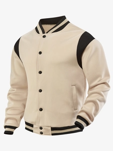 Detail of a beige and black varsity jacket featuring striped ribbing and snap buttons