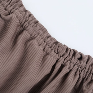 Macro detail of elastic waistband on coffee brown ribbed knit bodycon dress